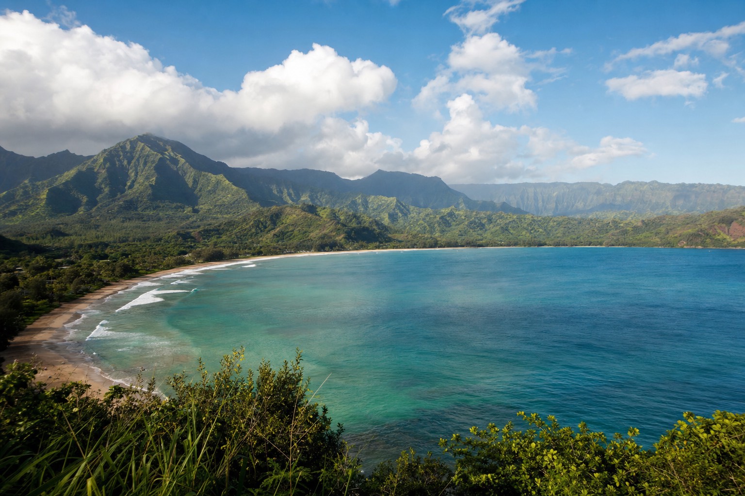 Hanalei Bay curving beneath green mountains on Kauai's north shore