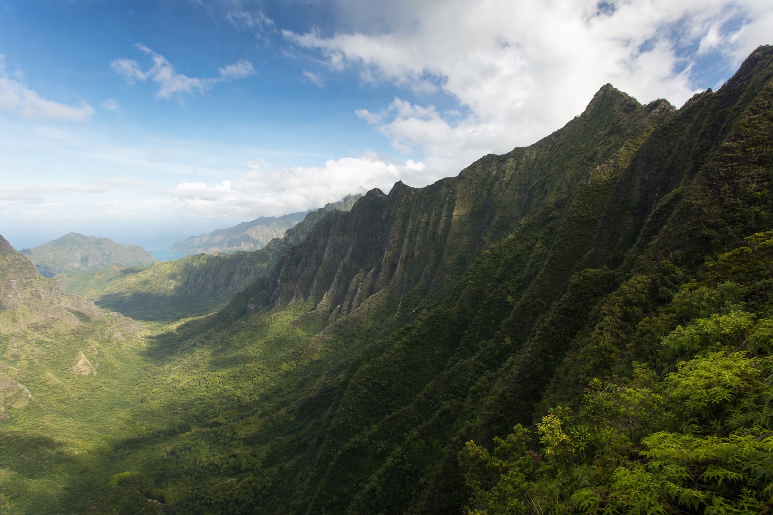 Empty green valley on Kauai with sheer fluted cliffs and no road or building in sight